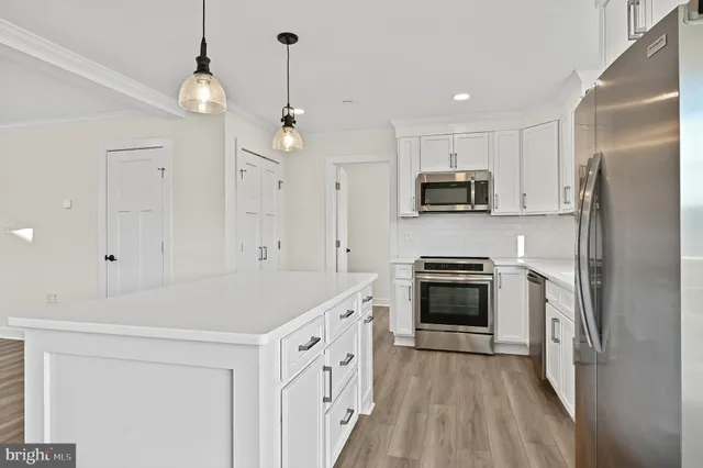 a kitchen with stainless steel appliances white cabinets and a stove