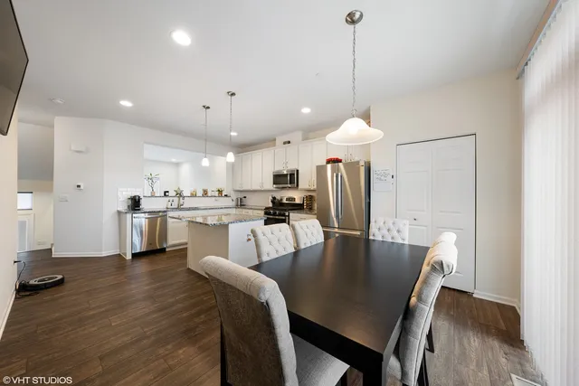 a dining room and kitchen with a table chairs a sink