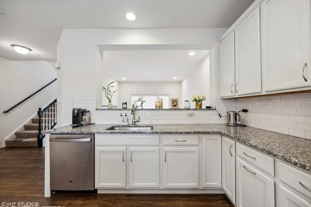 a kitchen with granite countertop a sink stainless steel appliances and cabinets