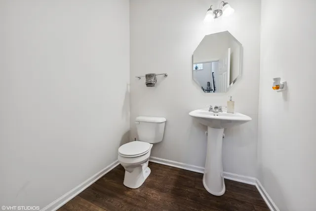 a bathroom with a sink toilet and a mirror