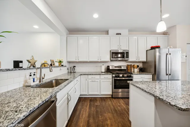 a kitchen with granite countertop a sink stove and refrigerator