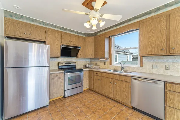 a kitchen with stainless steel appliances granite countertop a stove a sink dishwasher a refrigerator and a microwave oven with wooden floor