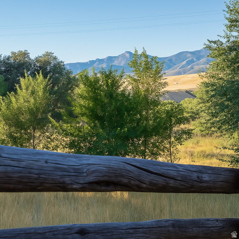 16535 South Redwood Road Riverton, UT 84065 - Photo 52 of 59 Property featuring a split-rail fence, mature trees, expansive fields, and distant mountains