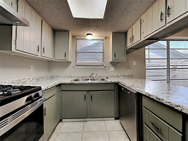 a kitchen with stainless steel appliances granite countertop a sink stove and cabinets