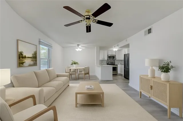 a living room with furniture and kitchen view