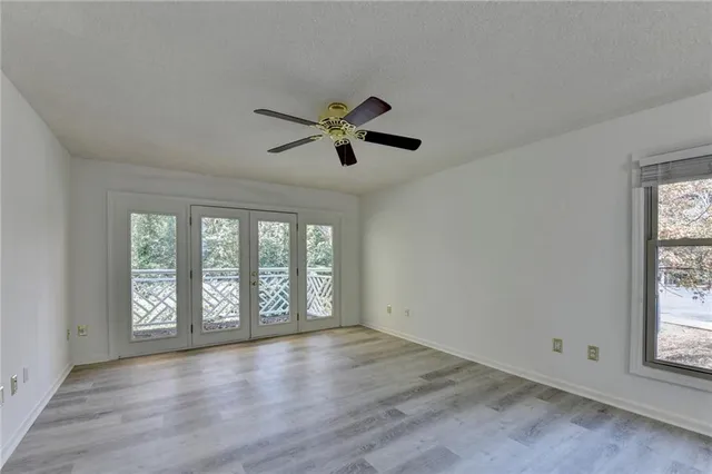 a view of empty room with wooden floor and window