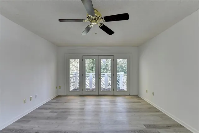 a view of a livingroom with a ceiling fan wooden floor and a ceiling fan
