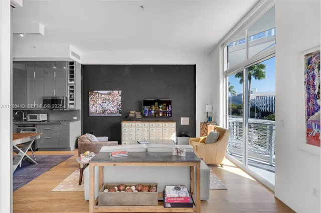a living room with furniture a rug and kitchen view