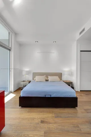 a bedroom with a bed and wooden floor