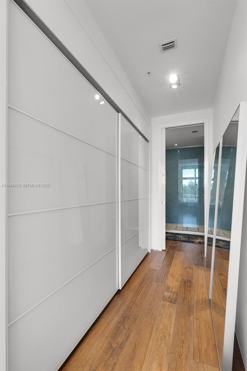 2001 Meridian Avenue, Unit 404 Miami Beach, FL 33139 - Photo 23 of 46 an empty room with wooden floor and mirror