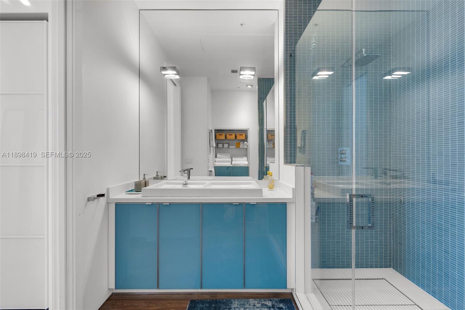 2001 Meridian Avenue, Unit 404 Miami Beach, FL 33139 - Photo 27 of 46 a bathroom with a sink a mirror and shower