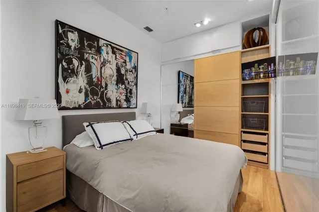 a bedroom with a bed and a painting on the wall