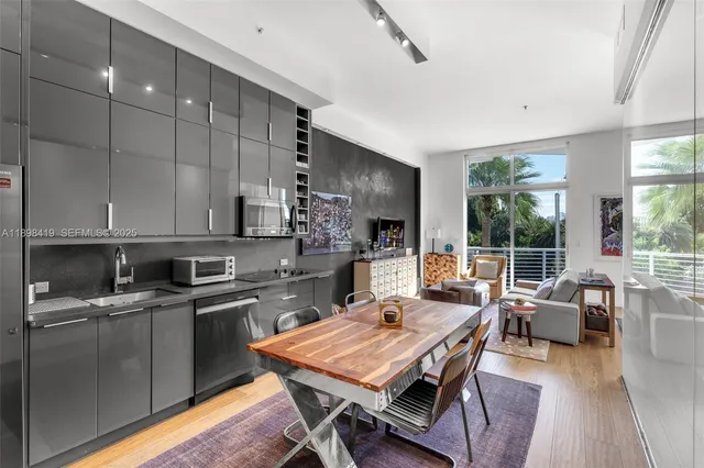 a large kitchen with a table chairs stove and wooden floor