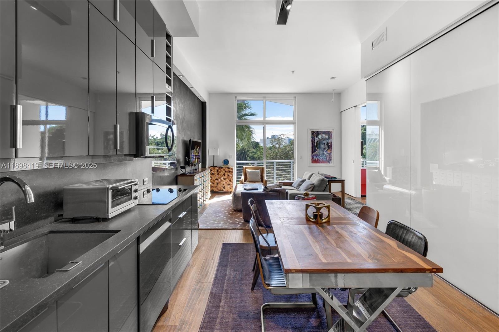 2001 Meridian Avenue, Unit 404 Miami Beach, FL 33139 - Photo 7 of 46 a large kitchen with a table chairs stove and wooden floor
