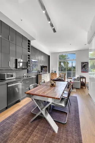 a room with stainless steel appliances kitchen island granite countertop a refrigerator and a stove top oven