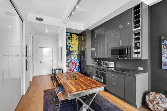 a large kitchen with stainless steel appliances a stove a sink dishwasher and cabinets with wooden floor