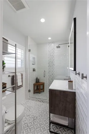 a spacious bathroom with a double vanity sink a mirror and a shower