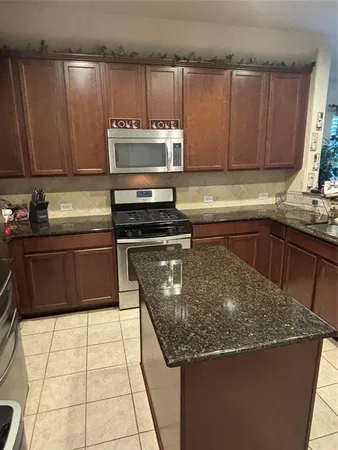 a kitchen with stainless steel appliances granite countertop a sink and a counter