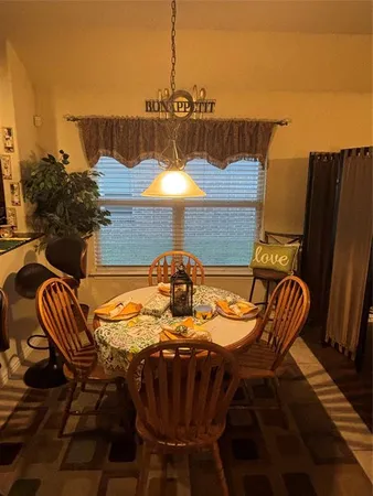 a living room with furniture a table and kitchen view