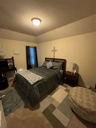 a bedroom with a bed a mirror and dresser