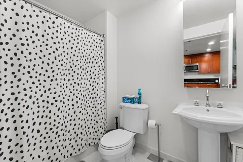 a bathroom with a sink toilet and a mirror