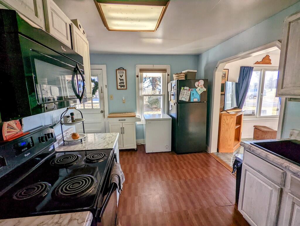 825 Macks Mountain Road Northwest Indian Valley, VA 24105 - Photo 14 of 30 a kitchen with stainless steel appliances granite countertop a stove a refrigerator a sink dishwasher and a stove with wooden floor