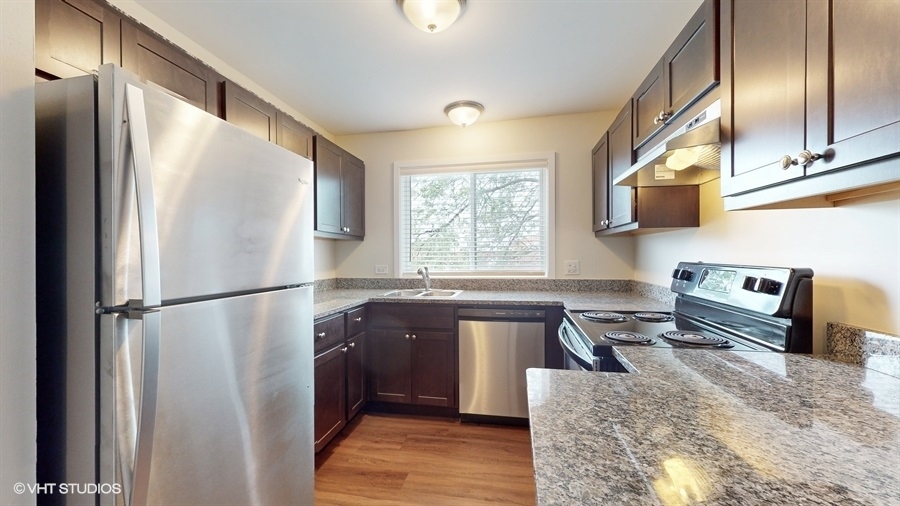 29-w542 Country Ridge Drive, Unit A Warrenville, IL 60555 - Photo 2 of 12 a kitchen with granite countertop a refrigerator and a sink