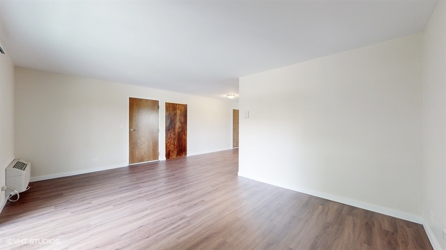29-w542 Country Ridge Drive, Unit A Warrenville, IL 60555 - Photo 5 of 12 a view of an empty room with wooden floor and closet