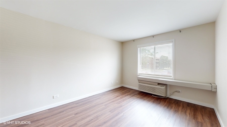 29-w542 Country Ridge Drive, Unit A Warrenville, IL 60555 - Photo 6 of 12 an empty room with wooden floor and windows