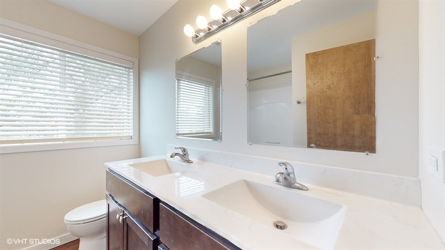 29-w542 Country Ridge Drive, Unit A Warrenville, IL 60555 - Photo 8 of 12 a bathroom with a sink and a mirror