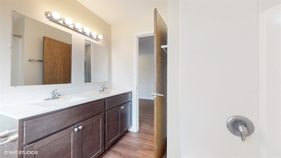 29-w542 Country Ridge Drive, Unit A Warrenville, IL 60555 - Photo 9 of 12 a bathroom with a double vanity sink and a mirror