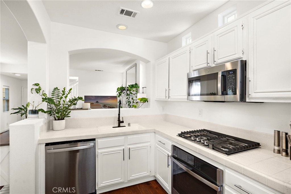 15 Honey Tree Ladera Ranch, CA 92694 - Photo 19 of 51 a kitchen with stainless steel appliances white cabinets a stove top oven and potted plant