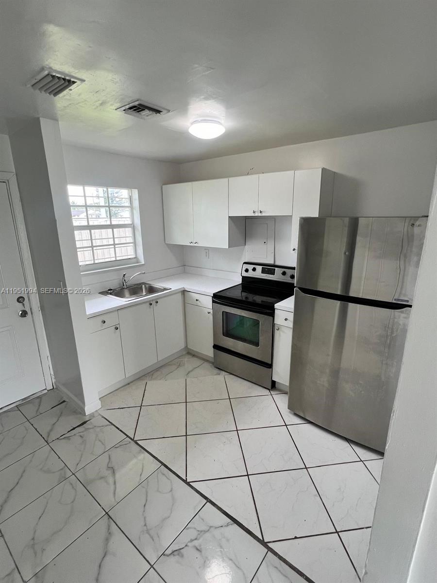 11535 Southwest 224th Street, Unit 2 Miami, FL 33170 - Photo 17 of 22 a kitchen with stainless steel appliances a refrigerator sink and cabinets