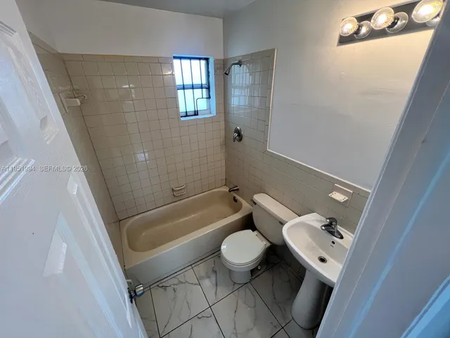 a bathroom with a tub and toilet