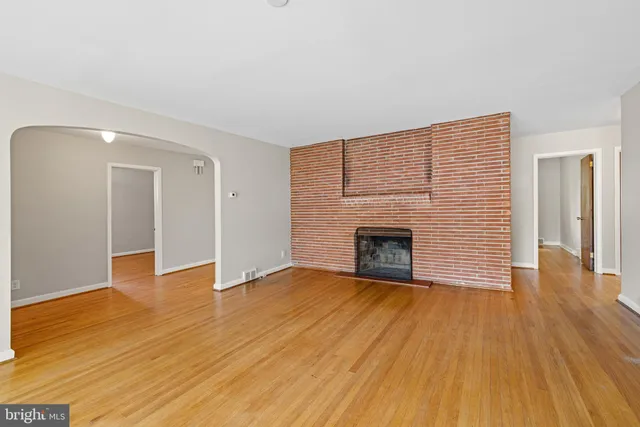 a view of empty room with wooden floor and fireplace