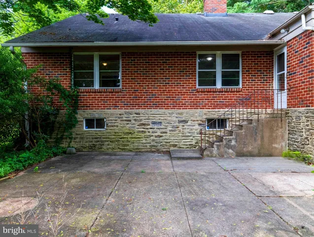 a view of a yard in front of a house with large trees
