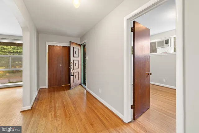 a view of a room with wooden floor and a bathroom