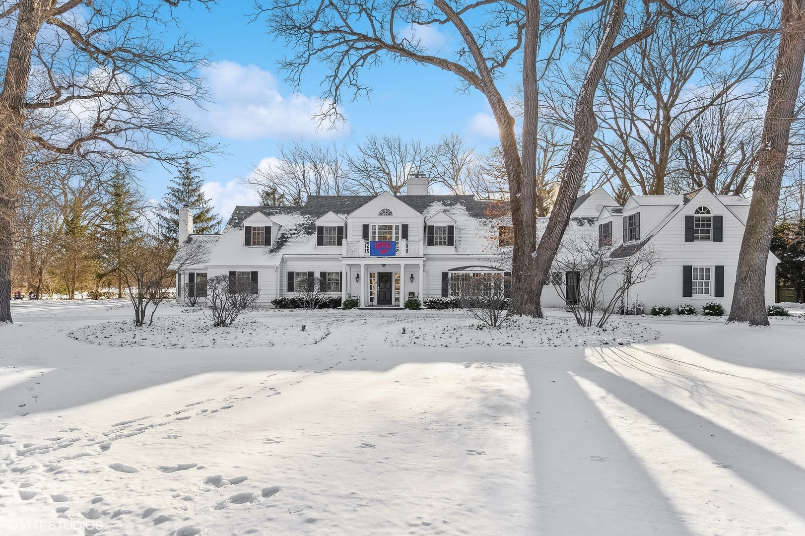 72 Woodley Road Winnetka, IL 60093 - Photo 4 of 9 a view of a large white house with a yard covered in snow