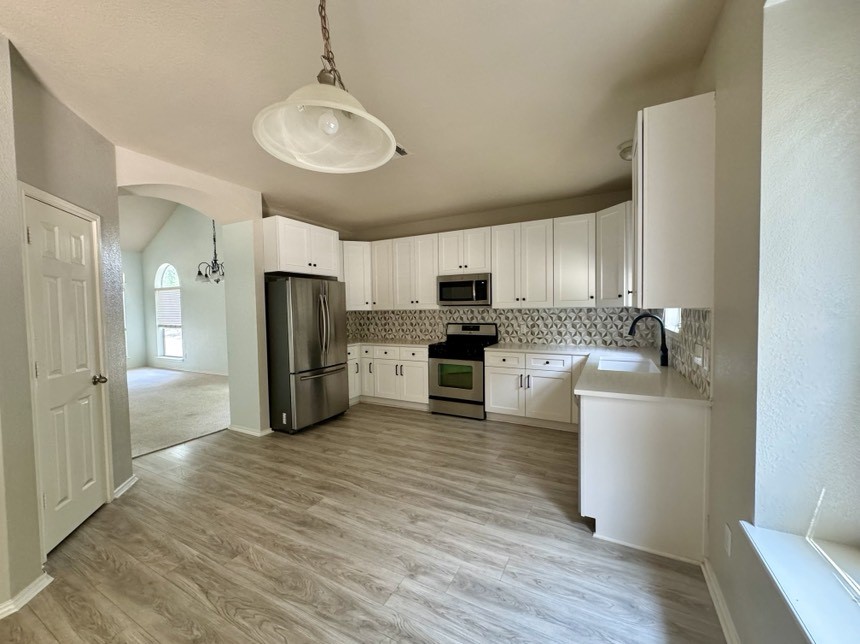 8301 Winterstein Drive Austin, TX 78745 - Photo 9 of 25 a kitchen with a sink stainless steel appliances and white cabinets