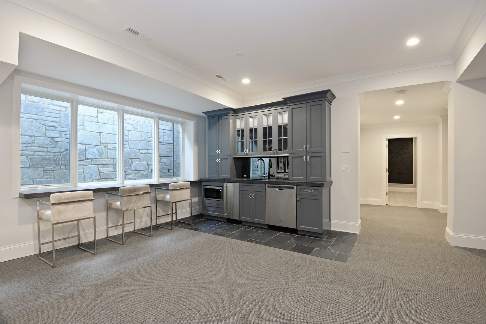 1003 Westmoor Road Winnetka, IL 60093 - Photo 32 of 38 a large white kitchen with kitchen island a large window a sink and stainless steel appliances