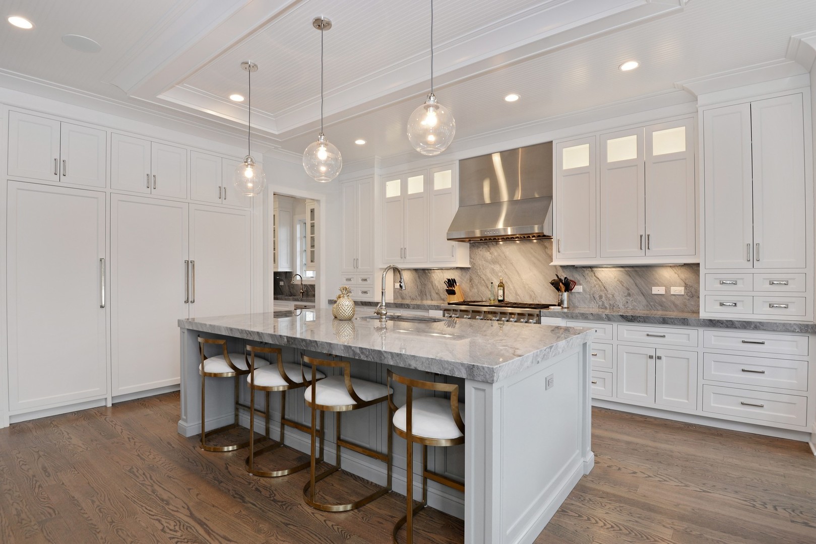 1003 Westmoor Road Winnetka, IL 60093 - Photo 6 of 38 a kitchen with stainless steel appliances granite countertop a table chairs sink and white cabinets