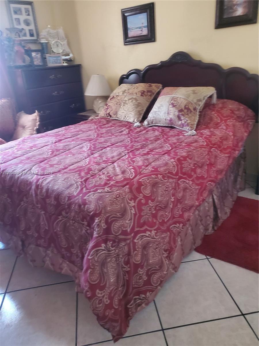 10953 West Okeechobee Road, Unit 101 Hialeah Gardens, FL 33018 - Photo 12 of 15 a bedroom with a bed and a couch
