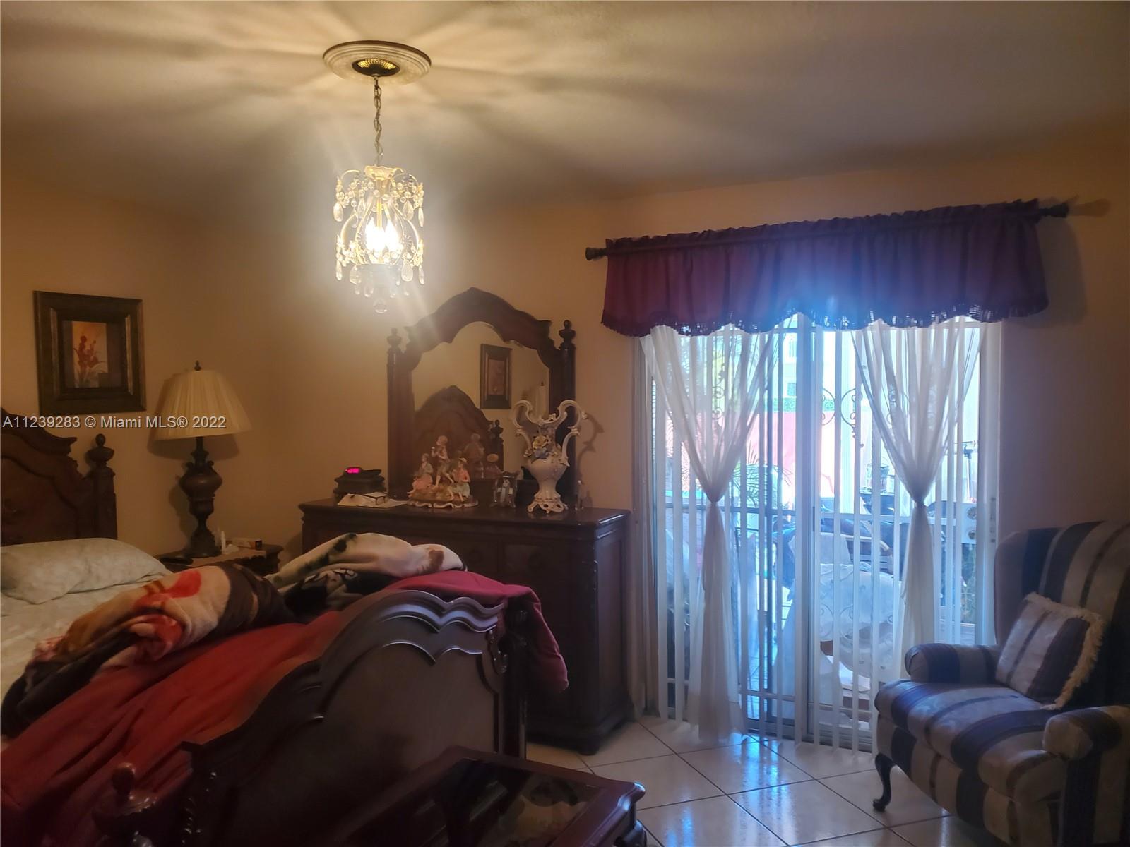 10953 West Okeechobee Road, Unit 101 Hialeah Gardens, FL 33018 - Photo 10 of 15 a view of a bedroom with a bed and couch