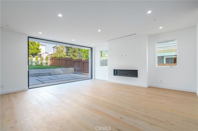 a living room with furniture a flat screen tv and a large window