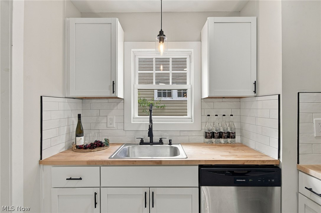 1173 Yellowstone Road Cleveland Heights, OH 44121 - Photo 15 of 44 White shaker-style cabinetry with matte black hardware, wood-finish countertops, stainless steel sink with a matte black faucet, and white subway tile backsplash