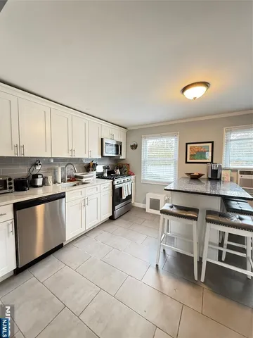 a kitchen with cabinets and chairs