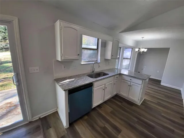 a kitchen with granite countertop white cabinets and white appliances