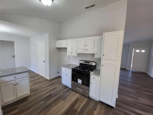 a kitchen with granite countertop a stove and a refrigerator