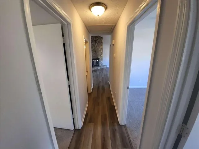 a view of a hallway with wooden floor and stairs