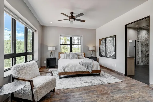a spacious bedroom with a bed and glass walk in closet